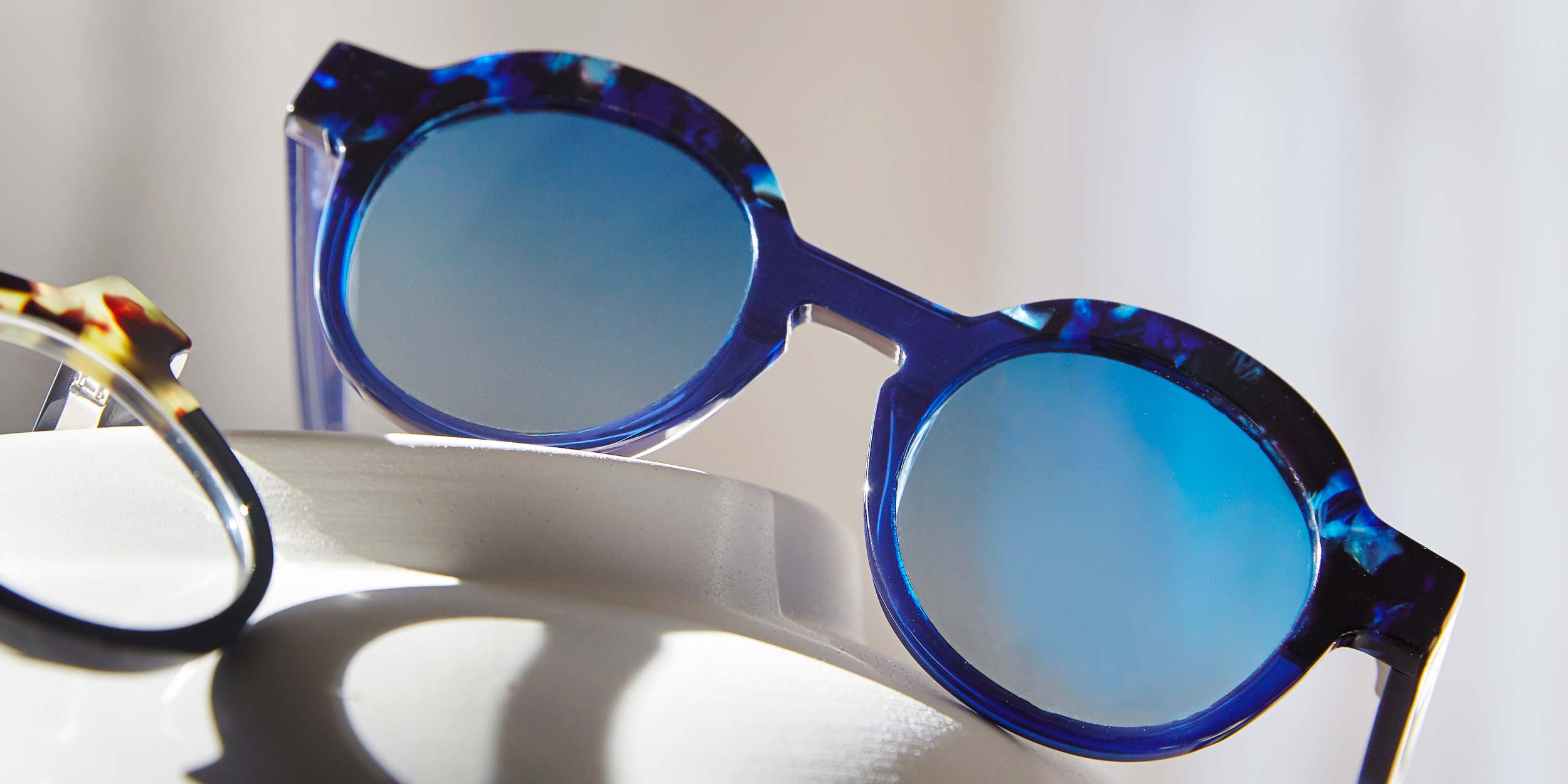 Photo Details of Charlotte Sun Clear Burgundy & Blue Marble Sun Glasses in a room