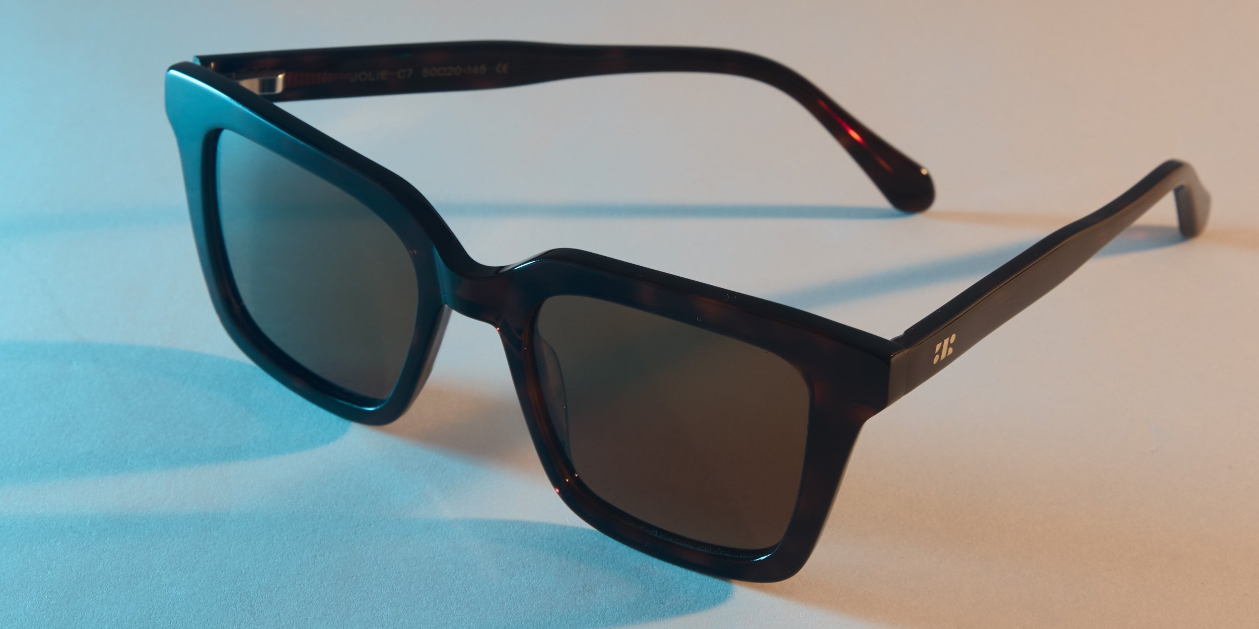 Photo Details of Jolie Sun Green Sun Glasses in a room
