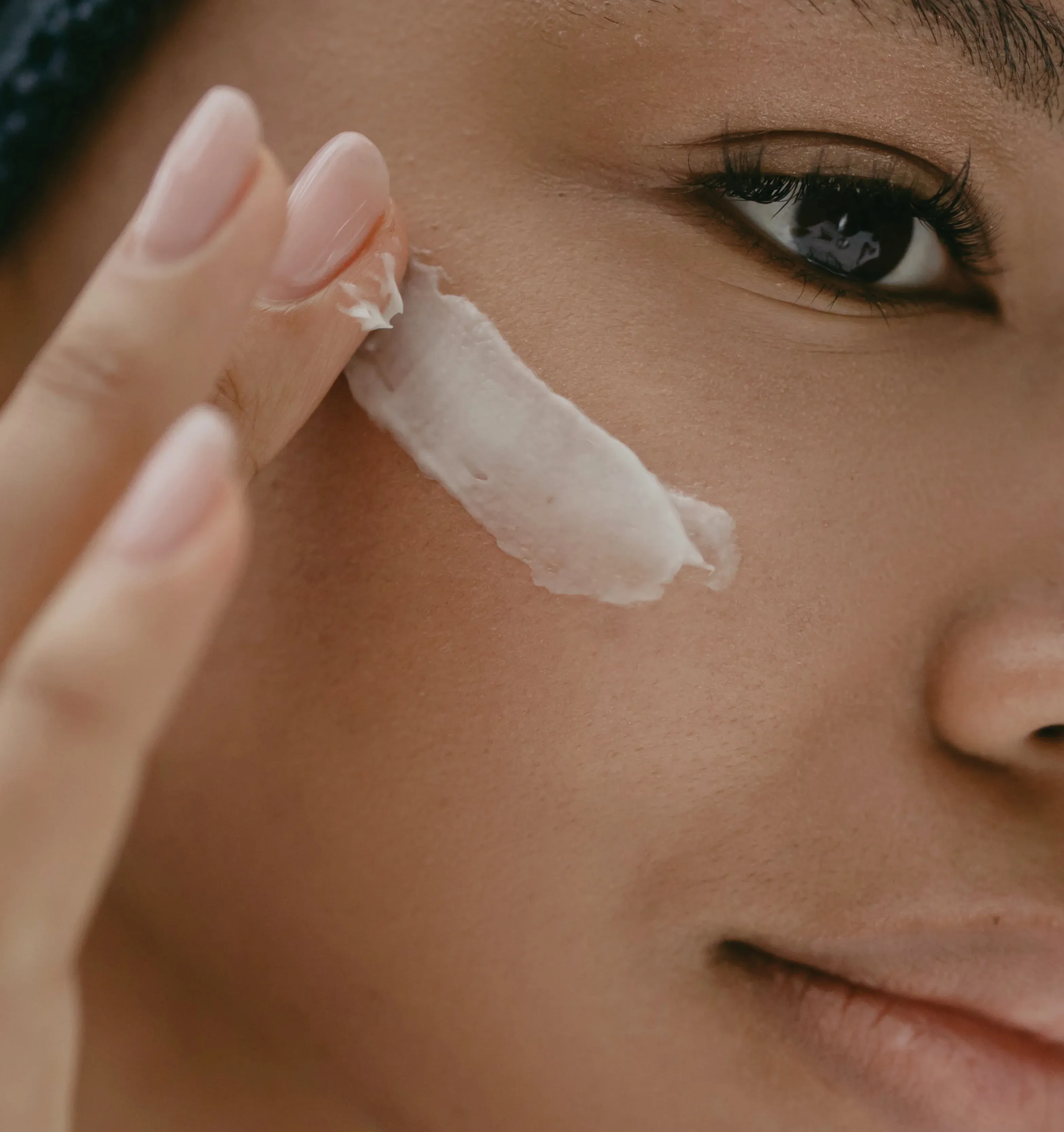 Person applying moisturiser to cheek