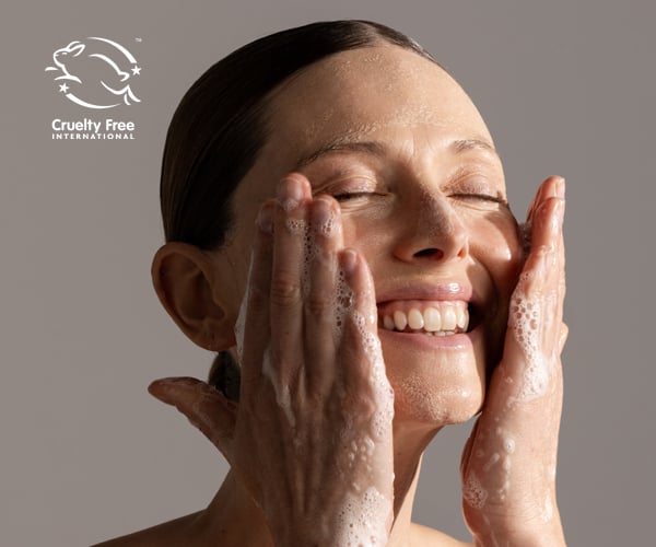 Model washing her face with skincare