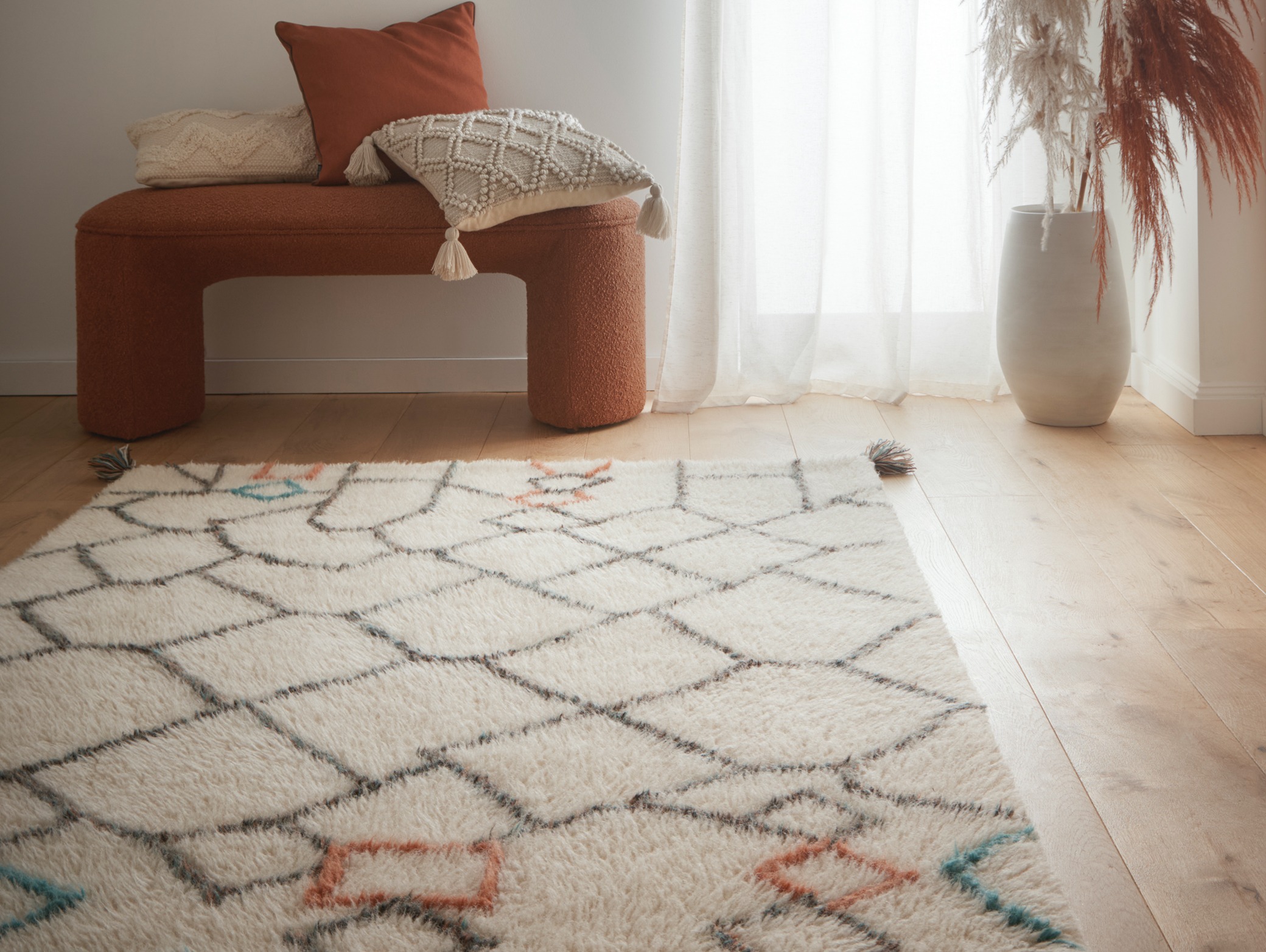 Berber Knotted Chain Wool Rug, styled on wooden flooring.