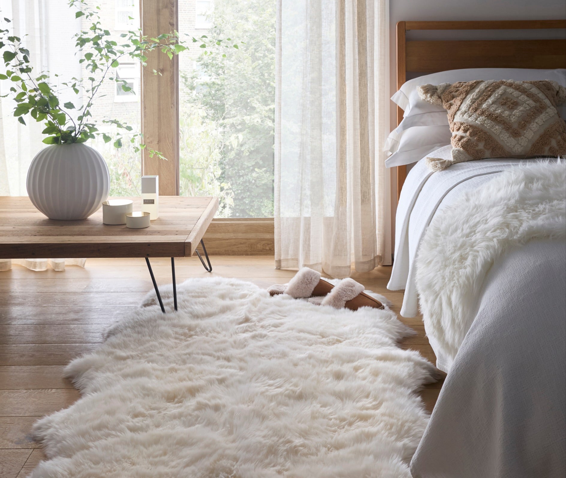 Sheepskin Rug Natural, styled next to the bed.