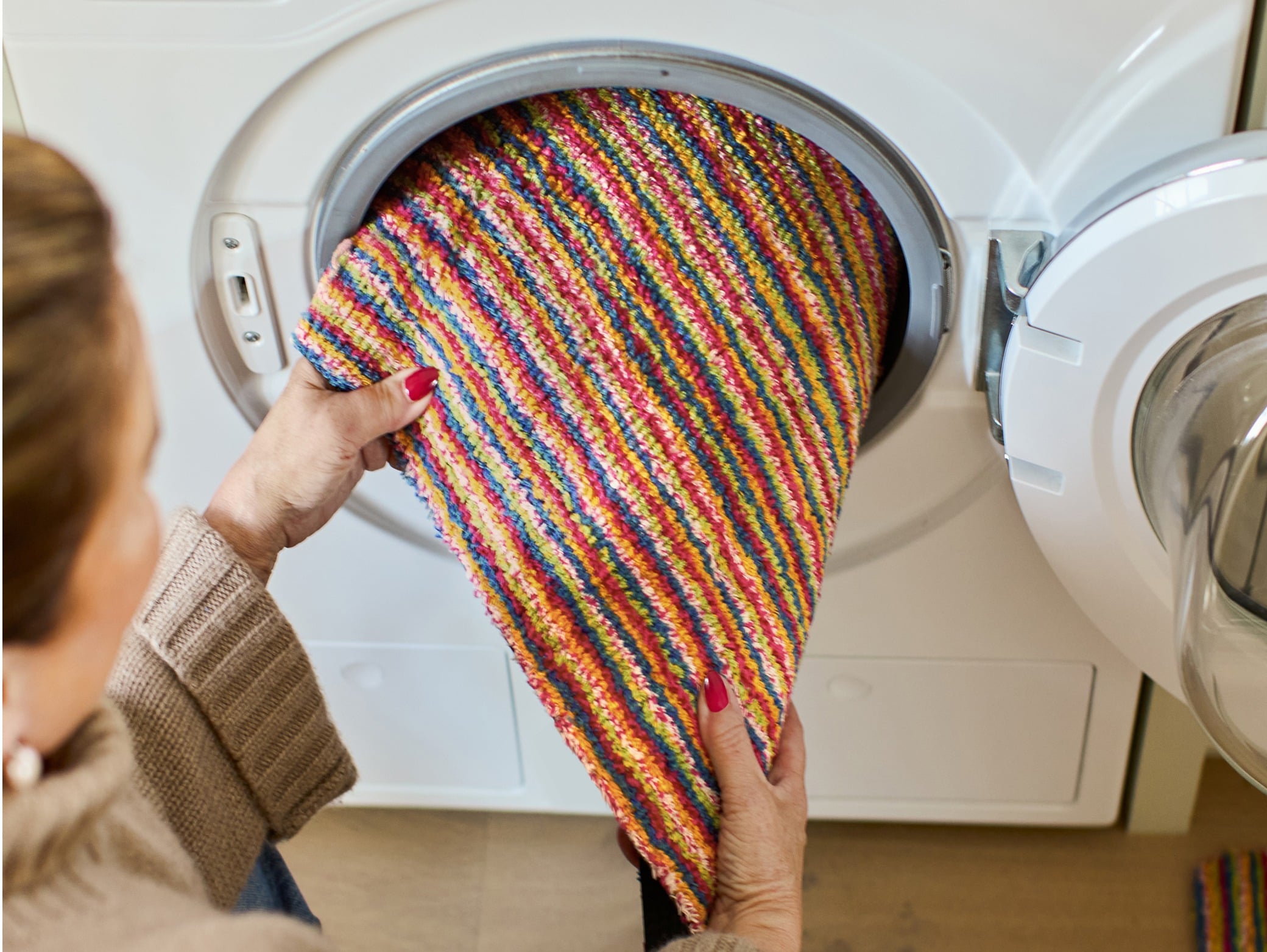 Candy Bright Stripe Washable Doormat, styled in a washing machine.